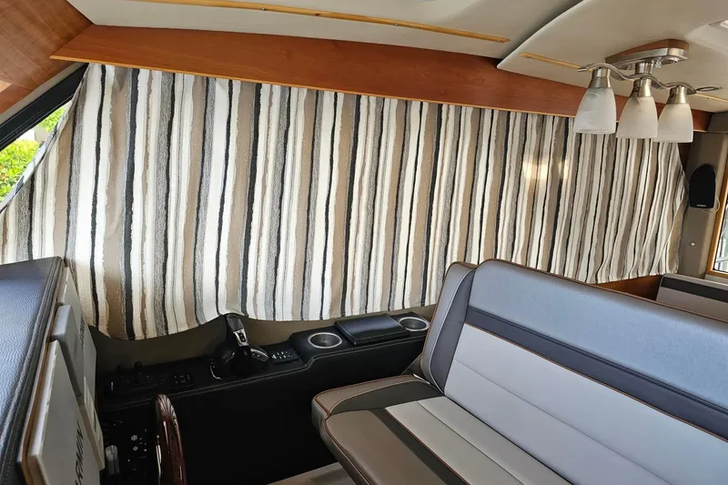 Slide: The Image of Interior of 2022 Cuwater C-32-CB with striped curtains and modern seating. - 22