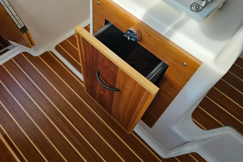 Slide: The Image of Open wooden drawer on Cuwater C-32-CB boat, 2022 model, with striped flooring. - 25