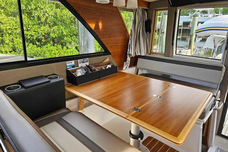 Slide: The Image of Interior of 2022 Cuwater C-32-CB boat with wooden table and seating area. - 30