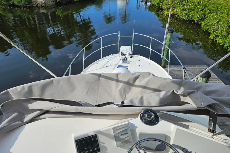 Slide: The Image of 2022 Cuwater C-32-CB boat docked by a serene waterway, featuring a Garmin navigation system. - 43