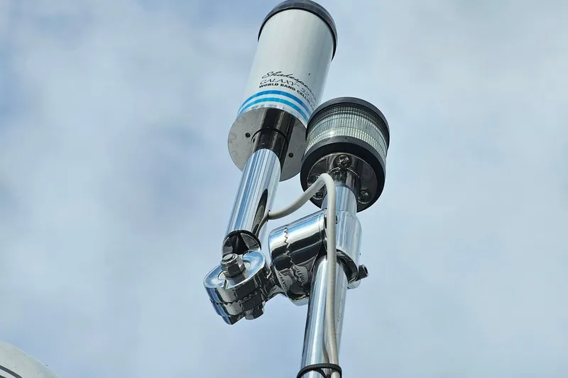 Slide: The Image of Antenna and light fixture on Cuwater C-32-CB, 2022 model, against cloudy sky. - 49