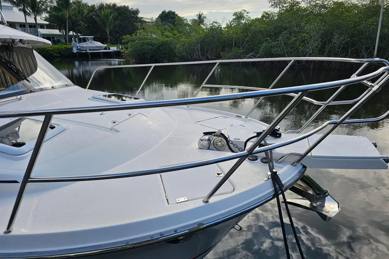 Slide: The Image of 2022 Cuwater C-32-CB boat docked on calm water with lush greenery. - 8