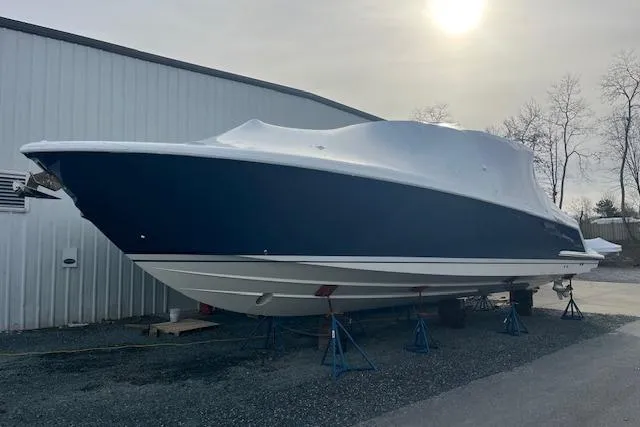 The Image of 2022 Tiara Yachts 43 LS boat covered and elevated on stands outdoors. - 0
