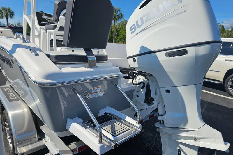 Slide: The Image of 2025 Sea Pro 202 Center Console boat with powerful outboard motor in a sunny parking lot. - 10