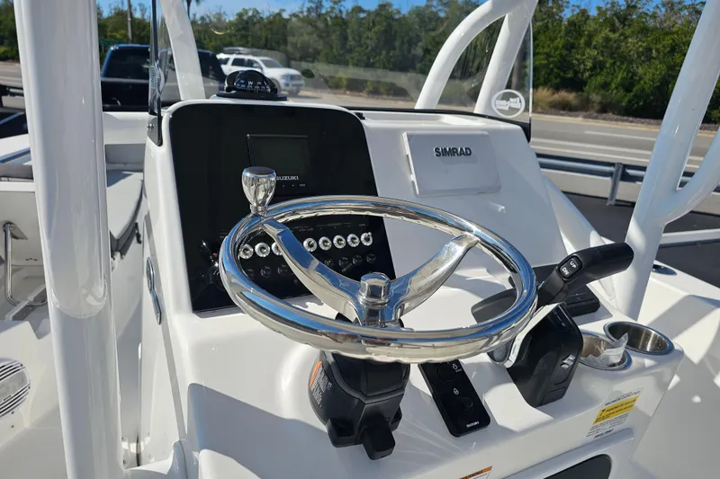 Slide: The Image of 2025 Sea Pro 202 Center Console boat with T-top and seating, under clear blue sky. - 20