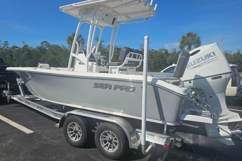 Slide: The Image of 2025 Sea Pro 202 Center Console boat on trailer, parked in a lot under clear blue sky. - 4
