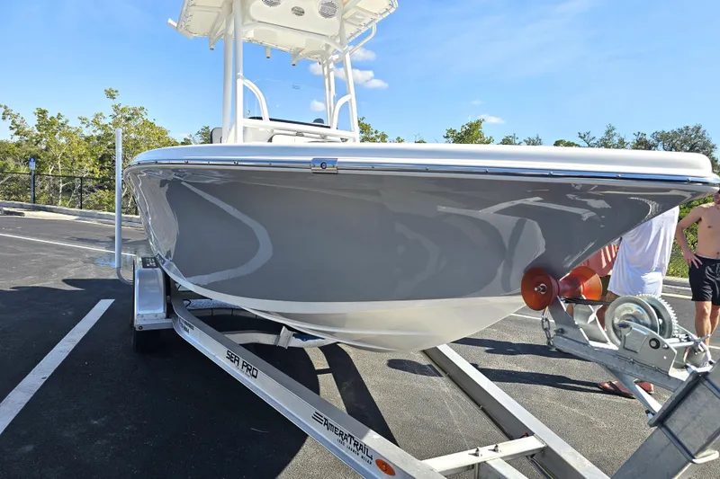 Slide: The Image of 2025 Sea Pro 202 Center Console boat on trailer, parked outdoors under clear blue sky. - 5