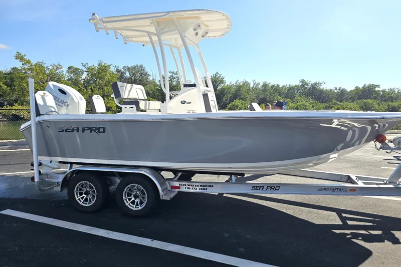 Slide: The Image of 2025 Sea Pro 202 Center Console boat on trailer with Suzuki engine, parked outdoors. - 6