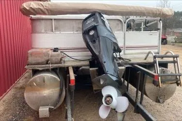 Slide: The Image of 2009 Palm Beach Sport Fish 1823 SE boat with outboard motor, parked near a red building. - 4