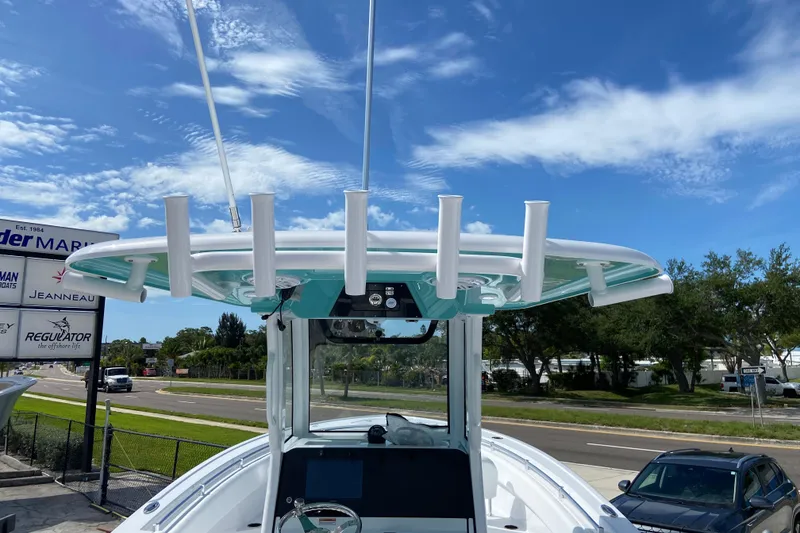 Slide: The Image of 2026 Sportsman Open 252 Center Console boat with rod holders, under a clear blue sky. - 18