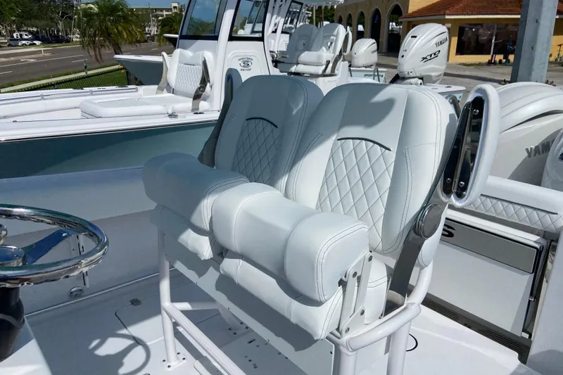 Slide: The Image of 2026 Sportsman Open 252 Center Console boat with luxurious white seating and steering wheel. - 19