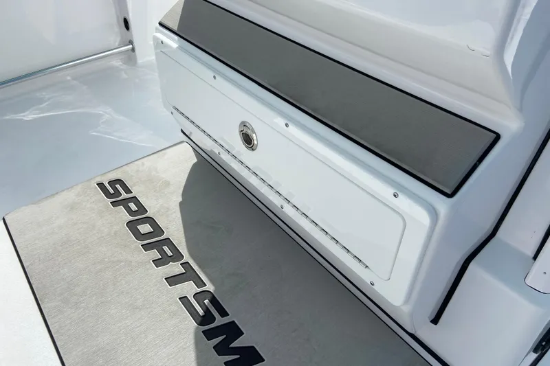 Slide: The Image of 2026 Sportsman Open 252 Center Console boat interior with branded flooring and storage compartment. - 27