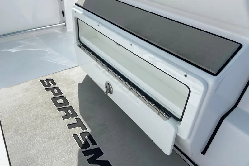 Slide: The Image of 2026 Sportsman Open 252 Center Console boat storage compartment with branded mat. - 28