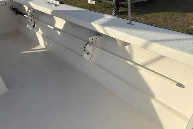 Slide: The Image of Interior of a 2014 Reno 23 boat showing rod holders and clean white deck. - 15