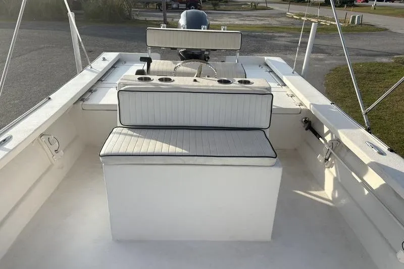 Slide: The Image of 2014 Reno 23 boat interior with cushioned seating and cup holders. - 17