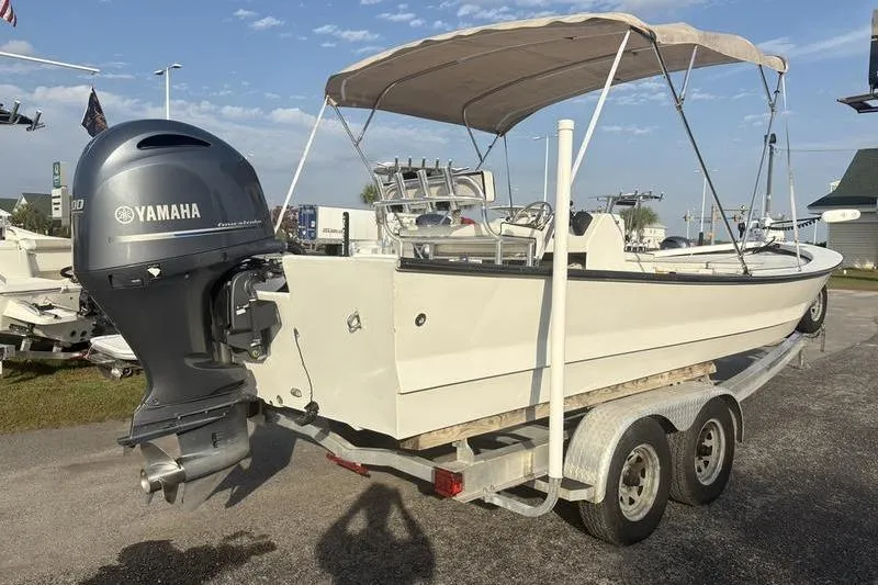 Slide: The Image of 2014 Reno 23 boat with Yamaha outboard motor on trailer, featuring canopy and dual axles. - 3
