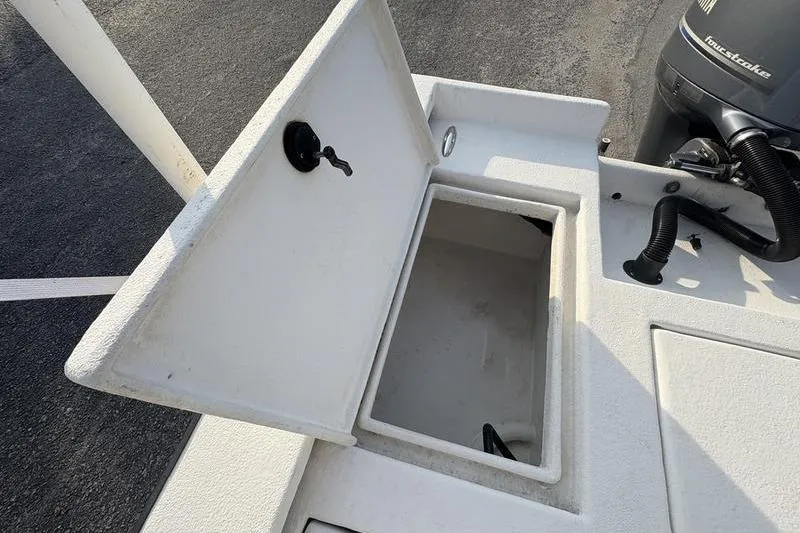 Slide: The Image of Open storage compartment on a 2014 Reno 23 boat, with visible engine components. - 8