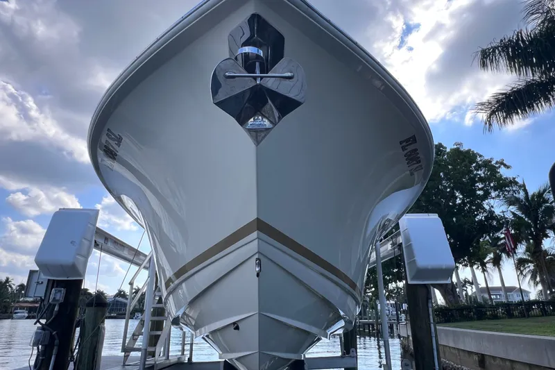 Slide: The Image of 2019 Scout 275 LXF boat docked under cloudy sky, front view. - 14