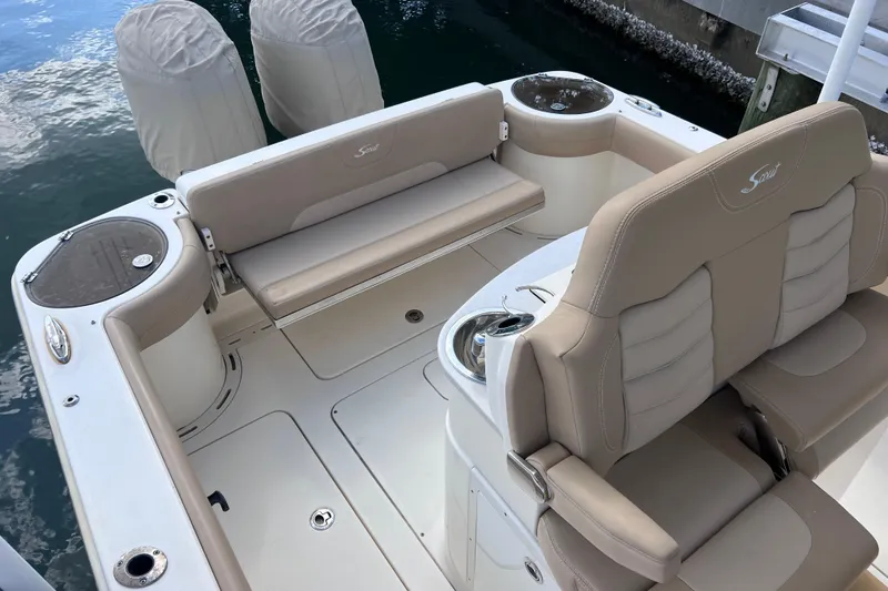 Slide: The Image of 2019 Scout 275 LXF boat interior with beige seating and fishing rod holders. - 17