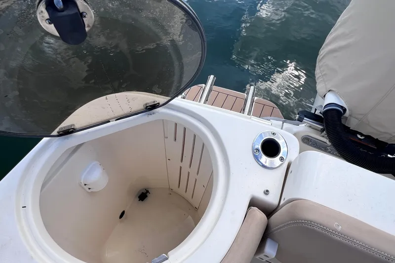Slide: The Image of Open hatch on 2019 Scout 275 LXF boat, showing interior compartment and water reflection. - 22