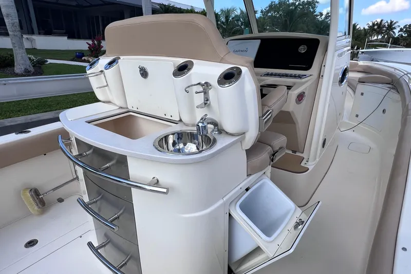 Slide: The Image of 2019 Scout 275 LXF boat interior with sink, storage, and seating. - 27