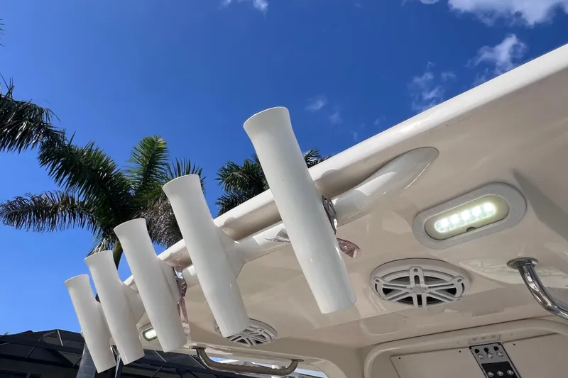 Slide: The Image of 2019 Scout 275 LXF boat with rod holders and speakers under a clear blue sky. - 36