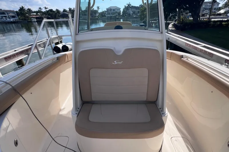 Slide: The Image of 2019 Scout 275 LXF boat interior with tan seating, docked by calm waters. - 67