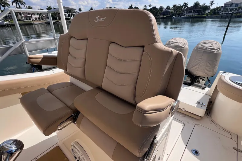 Slide: The Image of 2019 Scout 275 LXF boat with tan leather seating, docked by a serene waterfront. - 69