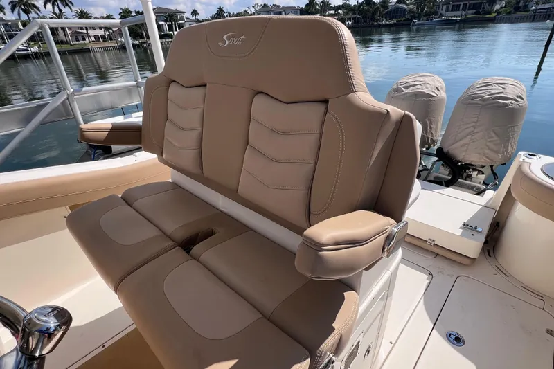 Slide: The Image of 2019 Scout 275 LXF boat interior with tan leather seating, docked by calm waters. - 70