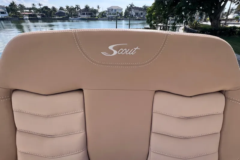 Slide: The Image of 2019 Scout 275 LXF boat seat with logo, overlooking waterfront homes. - 71