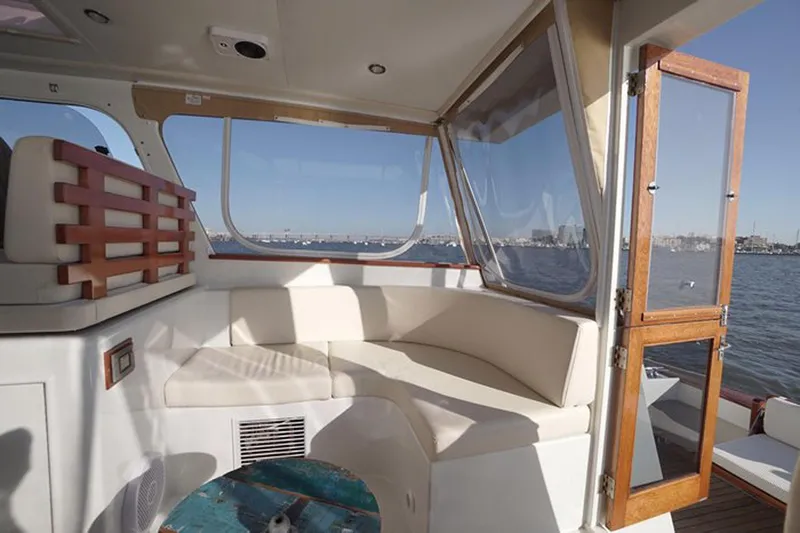 Slide: The Image of Interior of 2003 Huckins 44 Atlantic yacht with white seating and ocean view. - 14