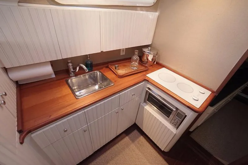 Slide: The Image of Compact galley kitchen in 2003 Huckins 44 Atlantic yacht with sink, stove, and storage. - 29