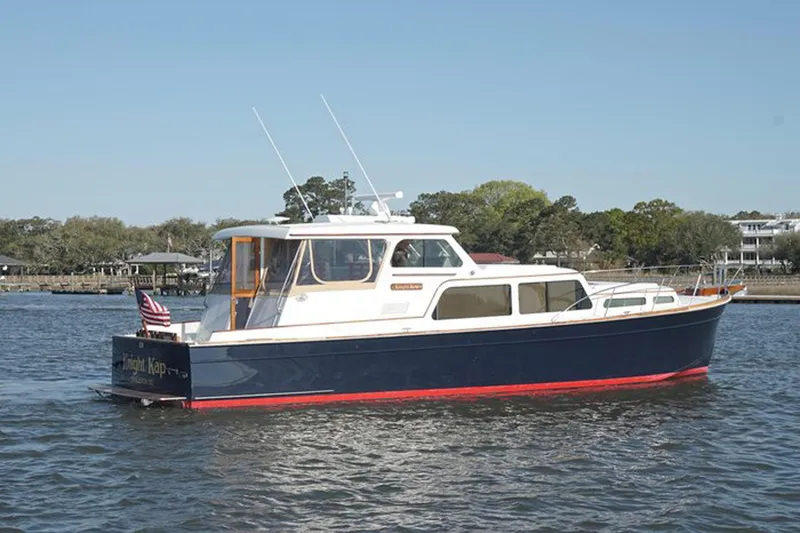 Slide: The Image of 2003 Huckins 44 Atlantic yacht on calm water, featuring classic design and American flag. - 3