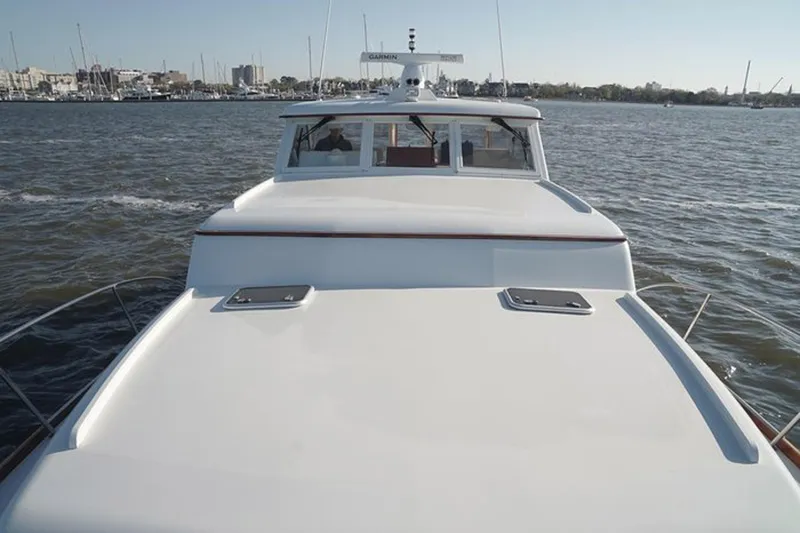 Slide: The Image of 2003 Huckins 44 Atlantic yacht on calm waters, showcasing sleek design and spacious deck. - 9
