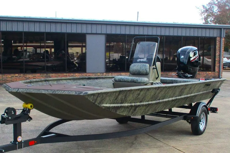 Slide: The Image of 2026 Tracker Grizzly 1860 CC boat on trailer, parked outside a building. - 11
