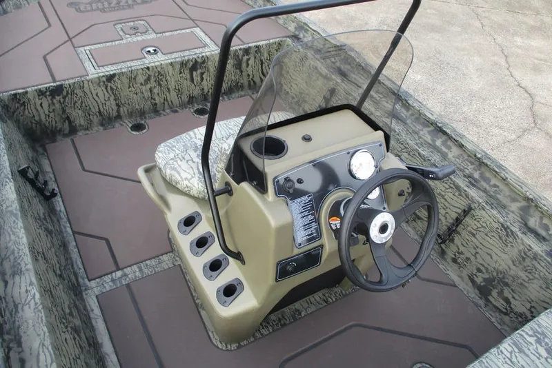 Slide: The Image of 2026 Tracker Grizzly 1860 CC boat interior with steering console and camouflage design. - 3
