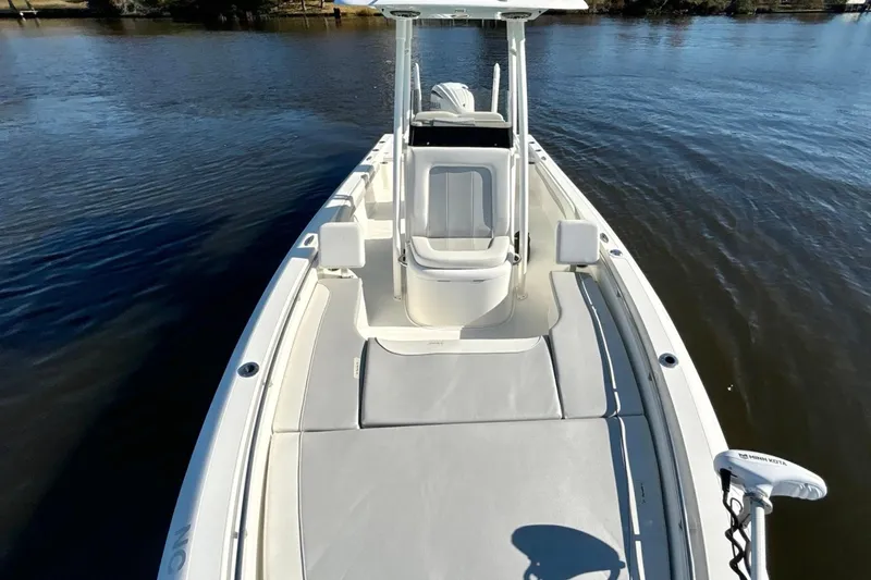 Slide: The Image of 2022 ShearWater 250 XTE boat on calm water, showcasing spacious deck and seating. - 12