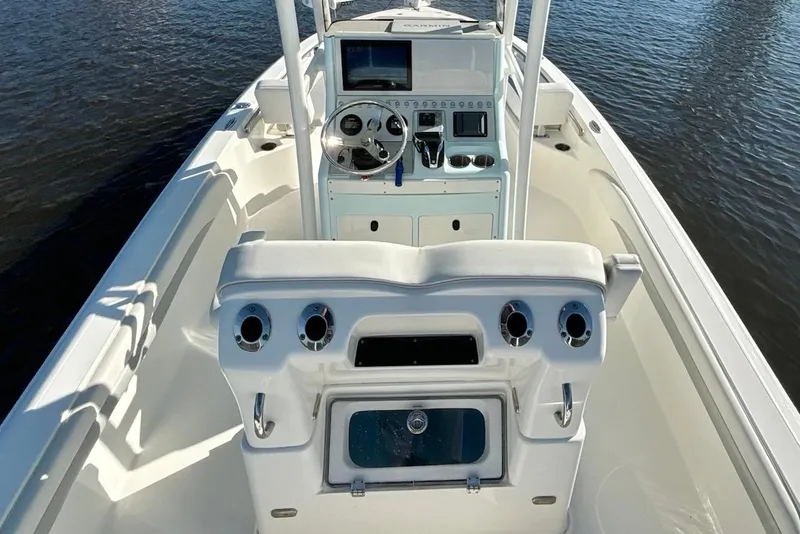 Slide: The Image of 2022 ShearWater 250 XTE boat interior with steering console and seating, on calm water. - 14