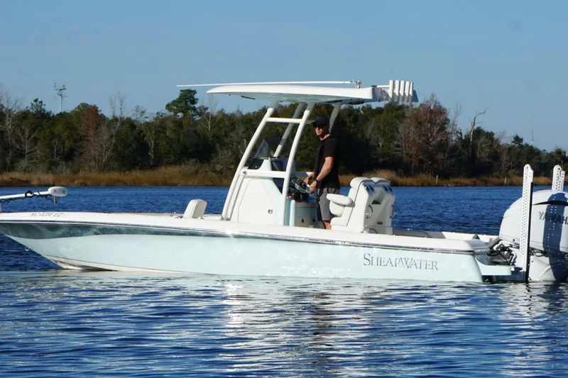 Slide: The Image of 2022 ShearWater 250 XTE boat on a calm lake with a person at the helm. - 3