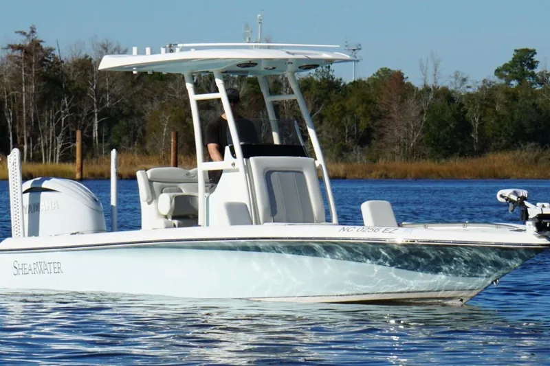 Slide: The Image of 2022 ShearWater 250 XTE boat on a calm lake with trees in the background. - 5