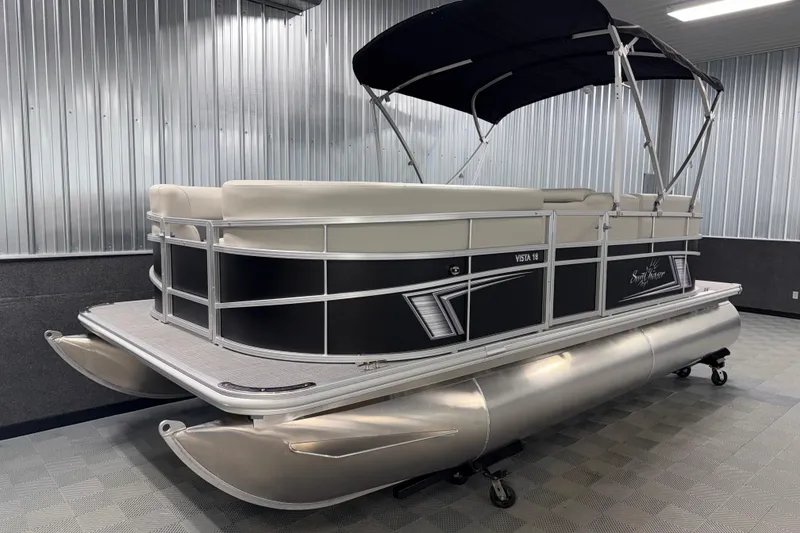 Slide: The Image of 2026 SunChaser Vista 18 LR pontoon boat in showroom, featuring sleek design and canopy. - 16