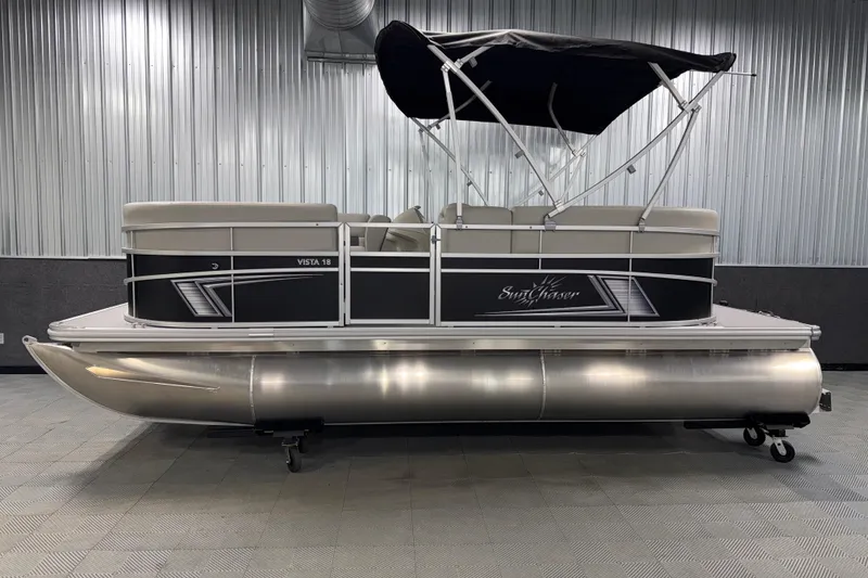 Slide: The Image of 2026 SunChaser Vista 18 LR pontoon boat with canopy in showroom setting. - 18