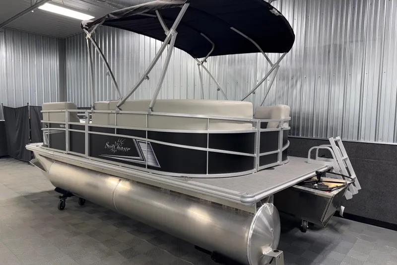 Slide: The Image of 2026 SunChaser Vista 18 LR pontoon boat in a metal-walled showroom. - 19