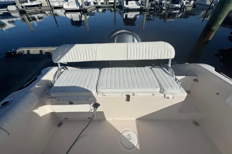 Slide: The Image of 2007 Cobia 237 Center Console boat with white seating at a marina. - 10