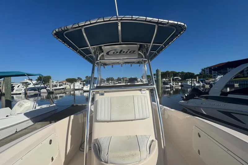 Slide: The Image of 2007 Cobia 237 Center Console boat docked at marina under clear blue sky. - 12