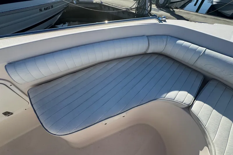 Slide: The Image of 2007 Cobia 237 Center Console boat with cushioned seating in a marina setting. - 14