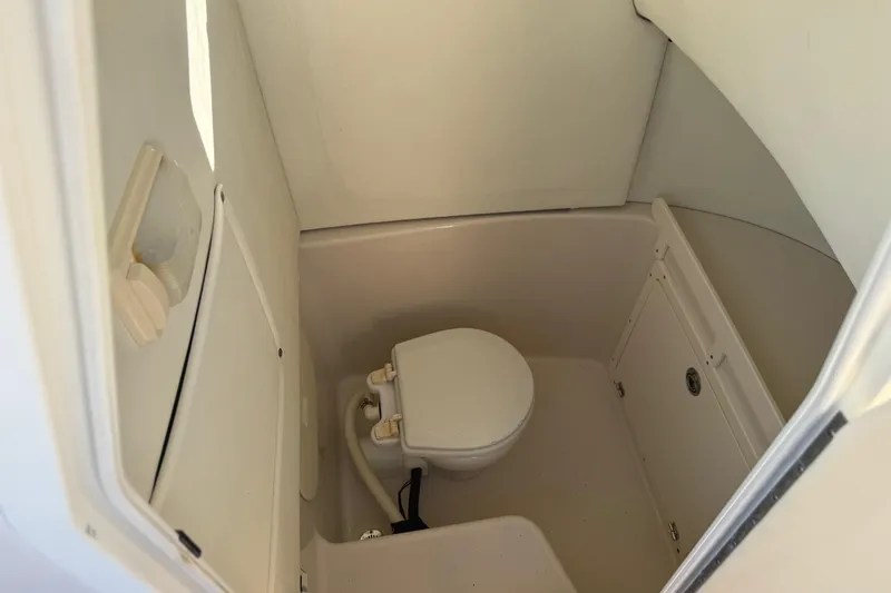 Slide: The Image of 2007 Cobia 237 Center Console boat interior with compact marine toilet. - 16