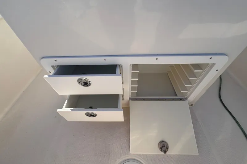 Slide: The Image of 2007 Cobia 237 Center Console storage compartments with open drawers and hatch. - 19