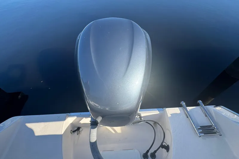 Slide: The Image of 2007 Cobia 237 Center Console boat engine and ladder on calm water. - 21