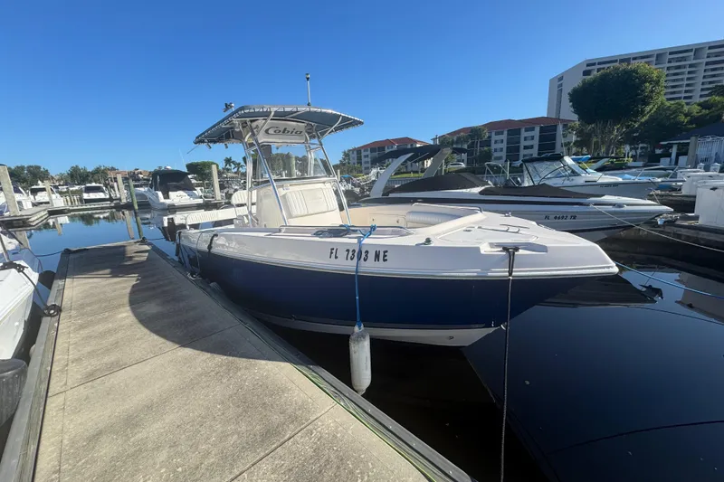 Slide: The Image of 2007 Cobia 237 Center Console boat docked at marina under clear blue sky. - 3